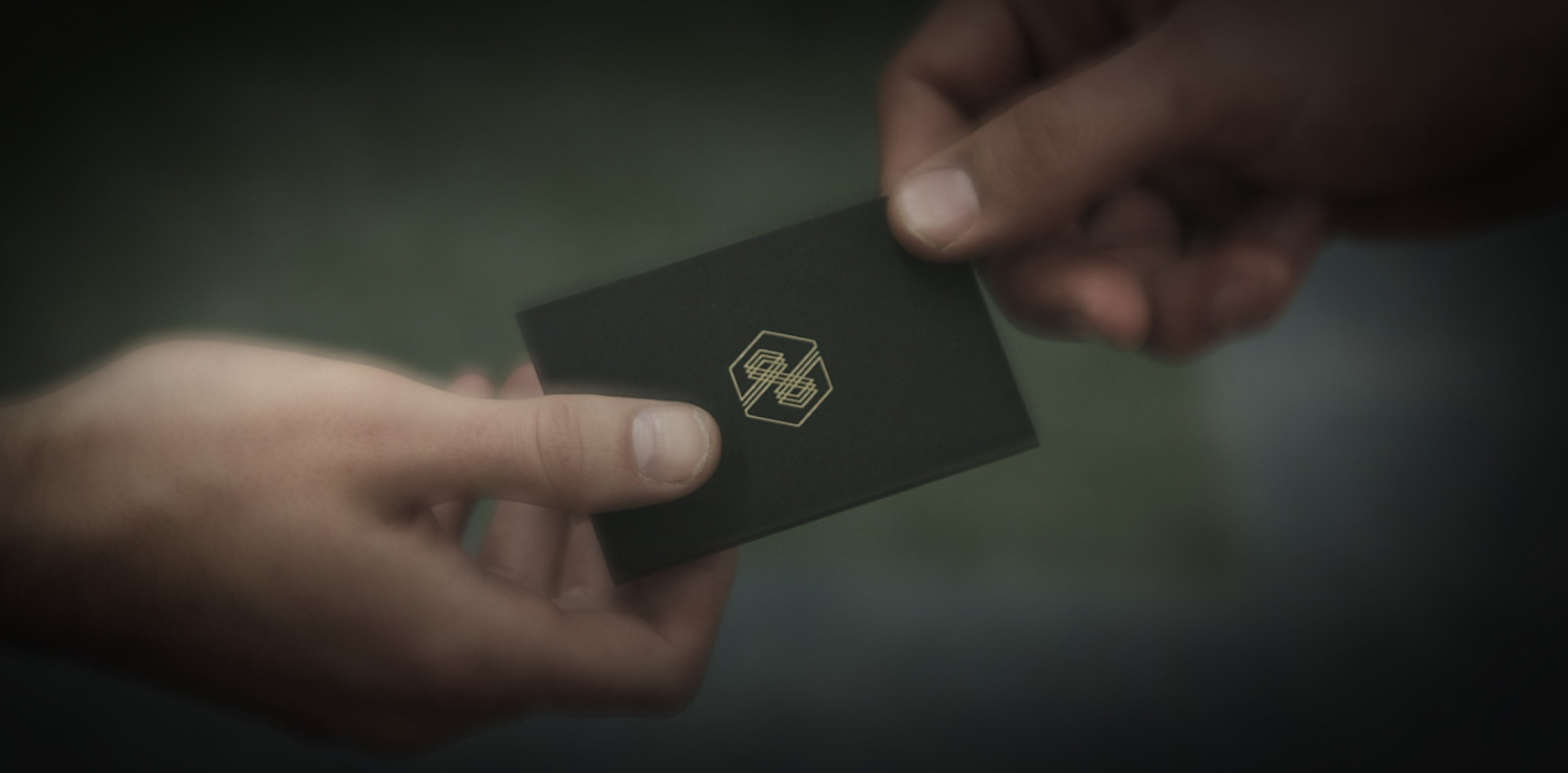 two people exchanging an invitation card