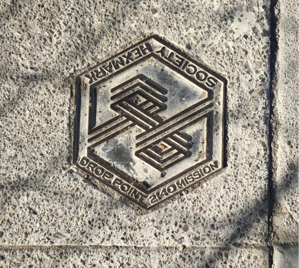 hexagonal marker embedded in sidewalk