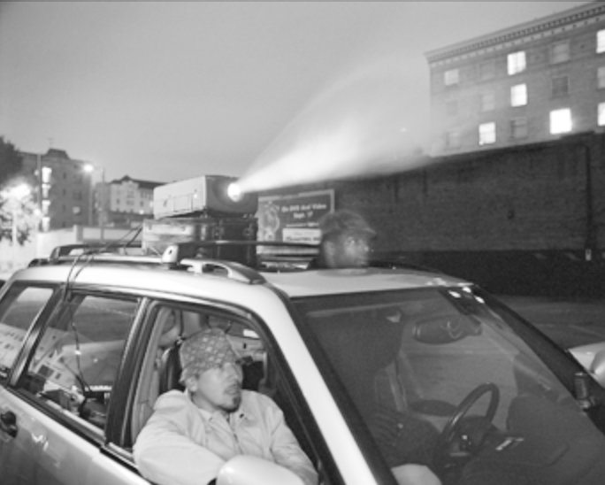 car projecting movie in parking lot