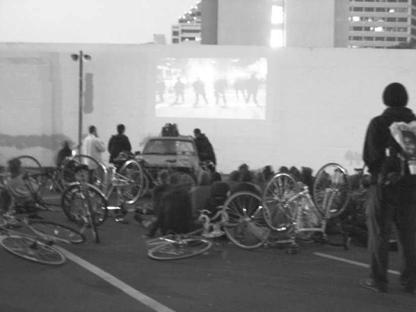 bicyclists sitting in a lot watching film